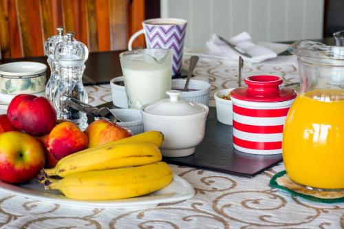 a plate of bananas and apples on a table with milk at Ribbonwood Country House in Cheviot