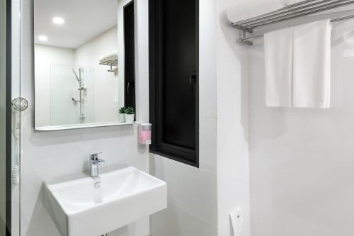 a white bathroom with a sink and a mirror at Hotel Z zpaze in Bangkok