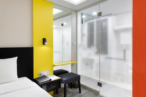 a bedroom with a bed and a yellow wall at Hotel Z zpaze in Bangkok