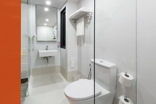 a white bathroom with a toilet and a sink at Hotel Z zpaze in Bangkok