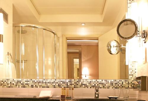 a bathroom with a shower and a large mirror at Crowne Plaza Limassol by IHG in Limassol