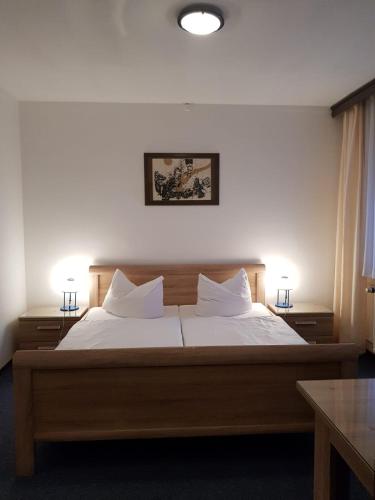 a bedroom with a bed with two lamps on it at Hotel zum Mückenberger Hof in Lauchhammer
