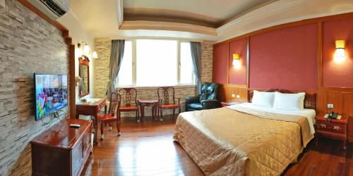 a hotel room with a bed and a tv at Aegean Garden Motel in Wujie