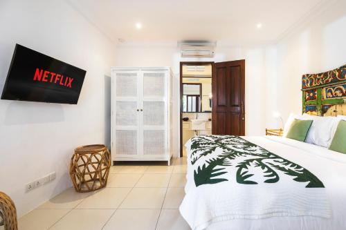 a bedroom with a bed and a sign on the wall at Villa Atma in Seminyak