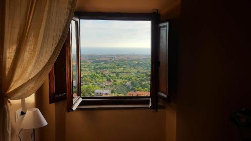 a window in a room with a view of a city at Locanda Il Sigillo B&B e Ristorante in Rosignano Marittimo