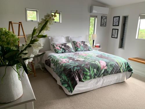 sypialnia z łóżkiem z kołdrą i poduszkami w obiekcie Peppertree lodge w mieście Havelock North