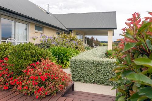 a house with flowers and plants in front of it at Ribbonwood Country House in Cheviot
