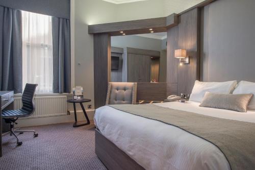a hotel room with a large bed and a desk at Crowne Plaza - Sheffield by IHG in Sheffield