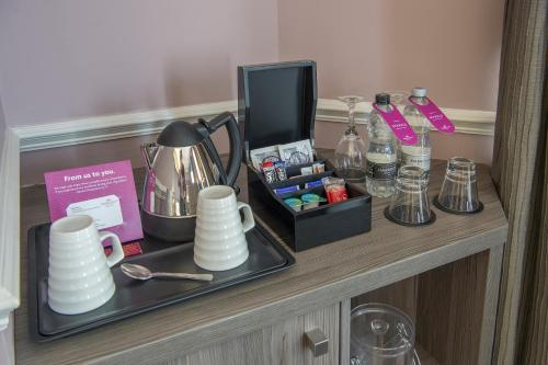 a table with a tray with cups and a box of perfume at Crowne Plaza - Sheffield by IHG in Sheffield