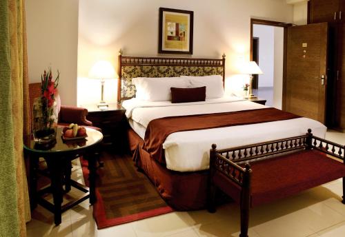 a bedroom with a large bed and a table at Avari Xpress, Islamabad in Rawalpindi