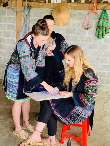 a group of people sitting on a red stool at My's Homestay sapa in Sa Pa