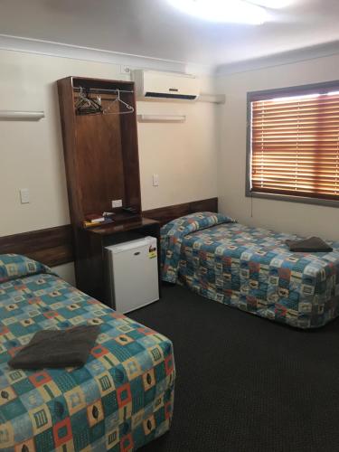 a hotel room with two beds and a window at Blackall Coolibah Motel in Blackall