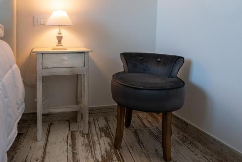 a bedroom with a chair next to a table at Il bianconido in Castel Gandolfo