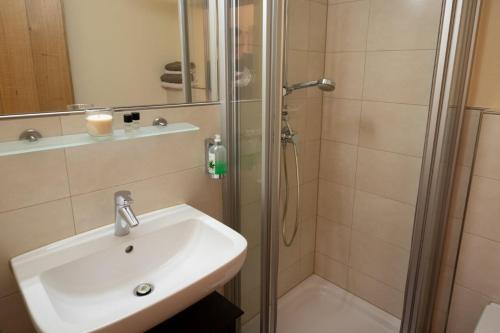 a bathroom with a sink and a shower at Gasthaus Murauer in Simbach am Inn