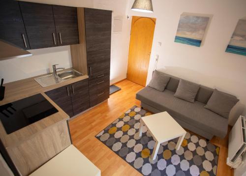 pequeña sala de estar con sofá y cocina en Nice Old Town Apartment, en Hall in Tirol