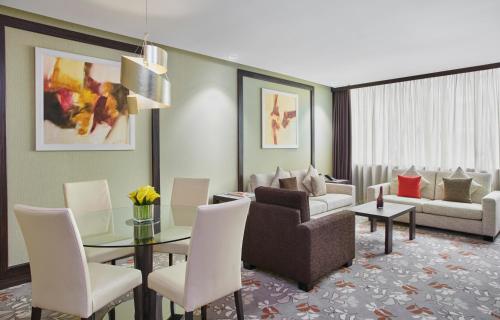 a living room with a couch and a table and chairs at Crowne Plaza Kuwait Al Thuraya City by IHG in Kuwait