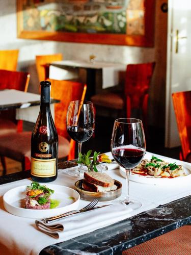 a table with two plates of food and wine glasses at Pokoje Gościnne WIDNOKRĄG in Sandomierz