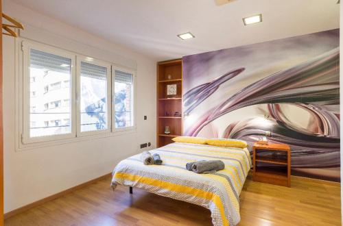a bedroom with a large painting on the wall at Ílios Soho Apartamentos in Málaga