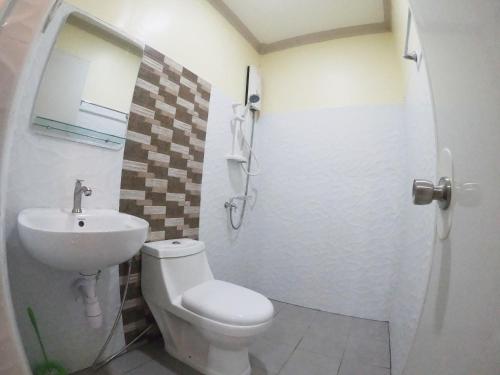 a bathroom with a toilet and a sink at Mifaña Suites - Panglao Island in Dauis