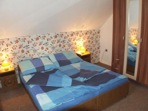 a bedroom with a bed with a blue comforter at Katalin nyaraló in Balatonkeresztúr