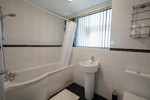 伯明罕的住宿－Birmingham BHX-HS2 -NEC APARTMENT，浴室配有盥洗盆、浴缸和卫生间。