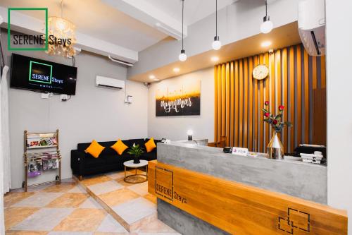 a waiting room with a counter and a couch at SERENE Stays Hotel in Yangon