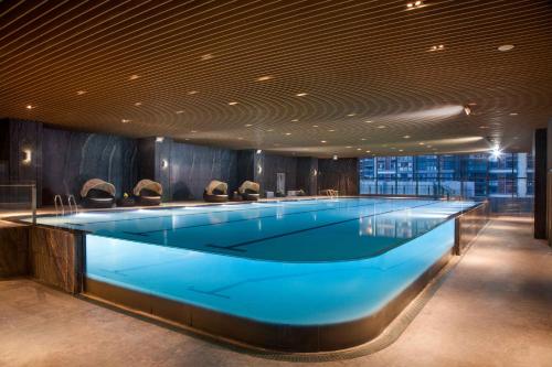 a large swimming pool with chairs in a building at Crowne Plaza Kunshan, an IHG Hotel in Kunshan