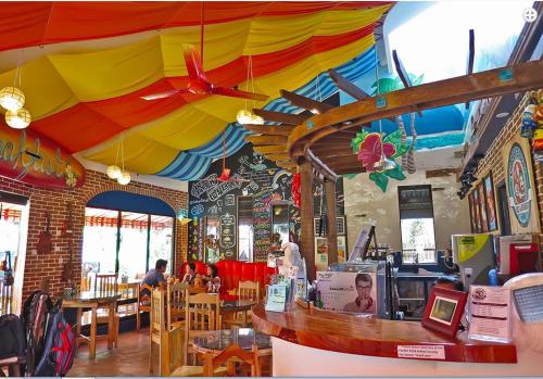 a restaurant with a colorful umbrella above a counter at Gabby's Bed & Breakfast in Dumaguete