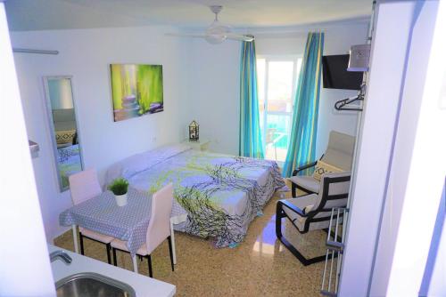 sypialnia z łóżkiem, stołem i krzesłami w obiekcie LOFT - GARAJE - TERRAZA PRIVADA Junto al Parque y Playa w mieście Conil de la Frontera