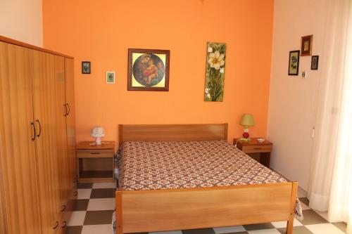 1 dormitorio con paredes de color naranja y 1 cama en una habitación en Splendida casa con vista sulla Baia di Gallipoli, en Nardò