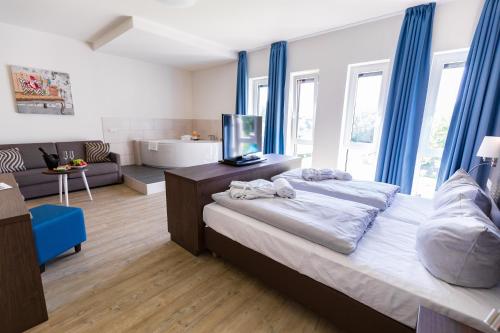 a bedroom with a large bed with blue curtains at Friendly Cityhotel Oktopus in Siegburg