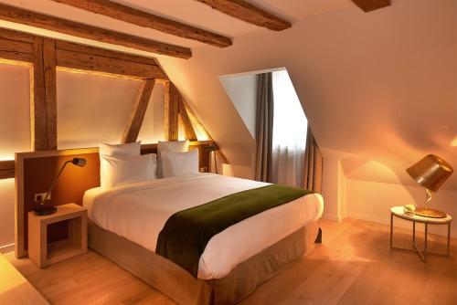 a bedroom with a large bed and a large window at 5 Terres Hotel & Spa - MGallery Collection in Barr