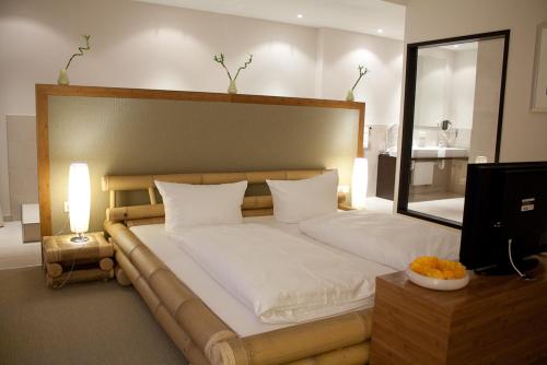 a bedroom with a large bed with a large mirror at Friendly Cityhotel Oktopus in Siegburg