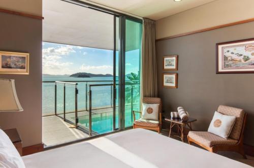 a bedroom with a bed and a view of the ocean at Yacht Club 19 Villa Bijou De Mer Ocean Front Private Pool 2 Buggies in Hamilton Island