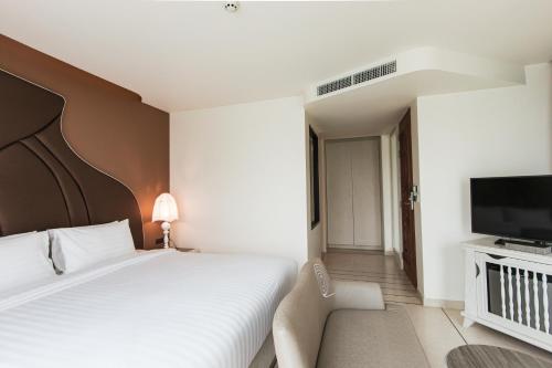 a hotel room with a bed and a television at Rachabhura Hotel in Ratchaburi