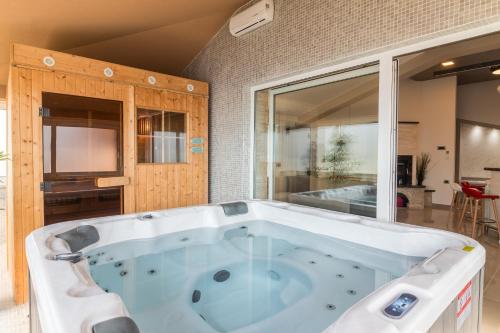 a large bath tub in a room with at Superb villa Maxima with private pool, sauna, jacuzzi, playground for up to 18 persons, extra pool heating available in Valtura