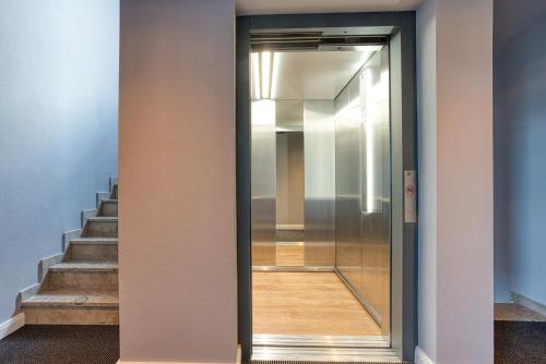 a glass door in a hallway with stairs at Vienna House Easy by Wyndham Ingolstadt in Ingolstadt