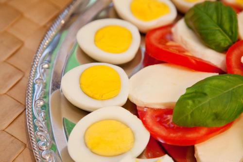 a plate of hard boiled eggs and tomatoes on a table at Hotel Bergidyll in Pfronten