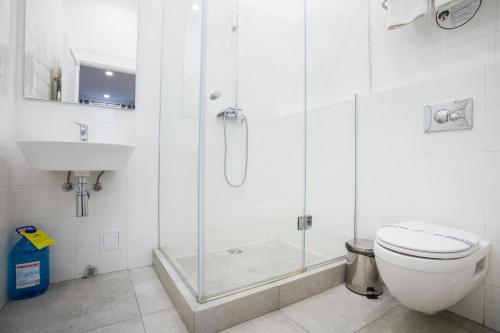y baño con ducha, aseo y lavamanos. en Partner Guest House Khreschatyk, en Kiev