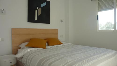 a bedroom with a large bed with two orange pillows at Guesthouse en Coveta fumà- El Campello in El Campello