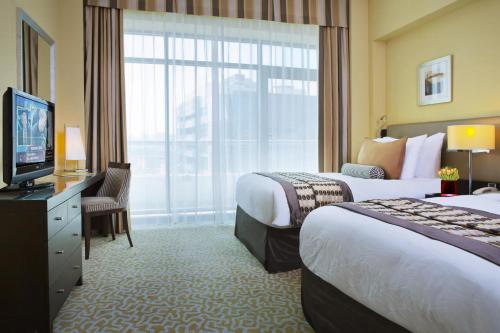 Habitación de hotel con 2 camas y TV en TIME Oak Hotel & Suites, en Dubái