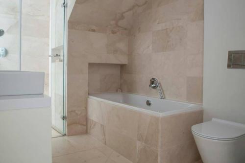 a bathroom with a bath tub and a toilet at Clifton 3rd Beach house - Breathtakingly Beautiful Views! in Cape Town