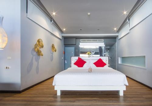 a bedroom with a white bed and red pillows at The Houben - Adult Only in Ko Lanta
