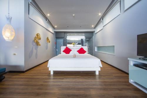 a bedroom with a white bed with red pillows at The Houben - Adult Only in Ko Lanta