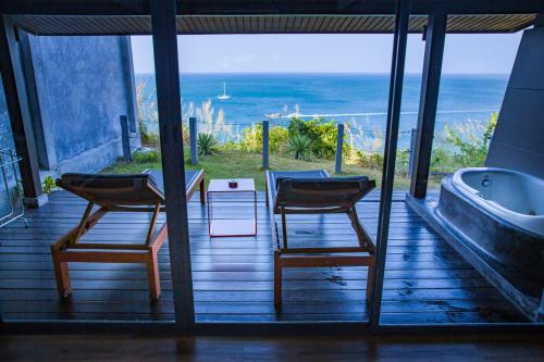 two chairs and a table and a bath tub on a porch at The Houben - Adult Only in Ko Lanta