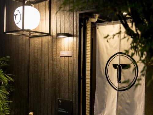 a door with a sign on the side of a building at TRIP POD MINOSHIMA A in Fukuoka