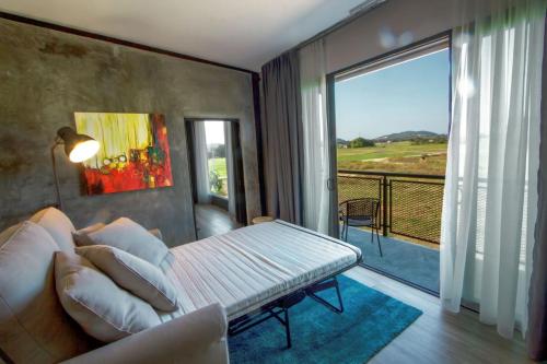 a living room with a couch and a balcony at VILLA PADDY in Kampung Padang Masirat