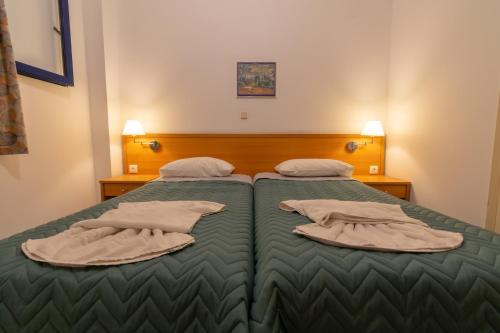 1 dormitorio con 2 camas con almohadas en Govino Bay, en Gouvia
