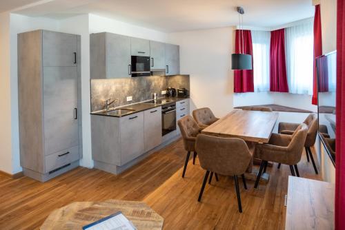 a kitchen and dining room with a table and chairs at Appartementhaus AURUM - Summercard included in Zell am See