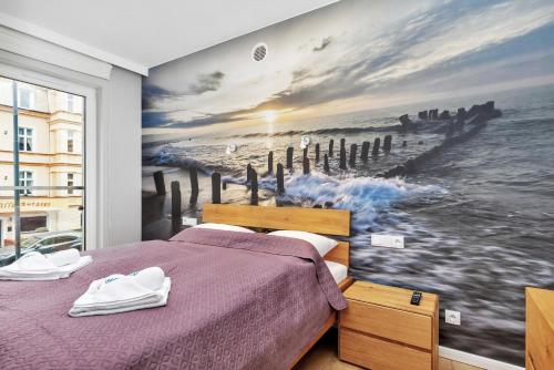 a bedroom with a large painting of the ocean at Premium Apartments Lissa by Renters in Świnoujście